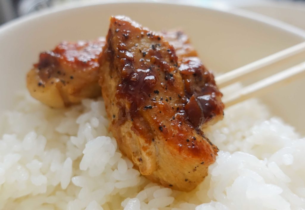 トンテキをご飯の上に乗せた画像です。タレの味が濃いので、ご飯の上でいったんバウンドさせて食べたくなりますね。